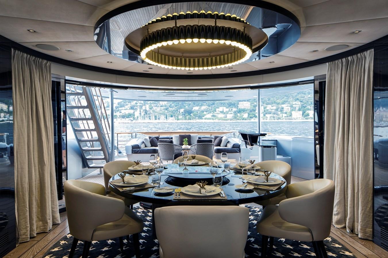 a dining room with a large chandelier aboard DYNAMIQ GTT 115  Yacht for Sale