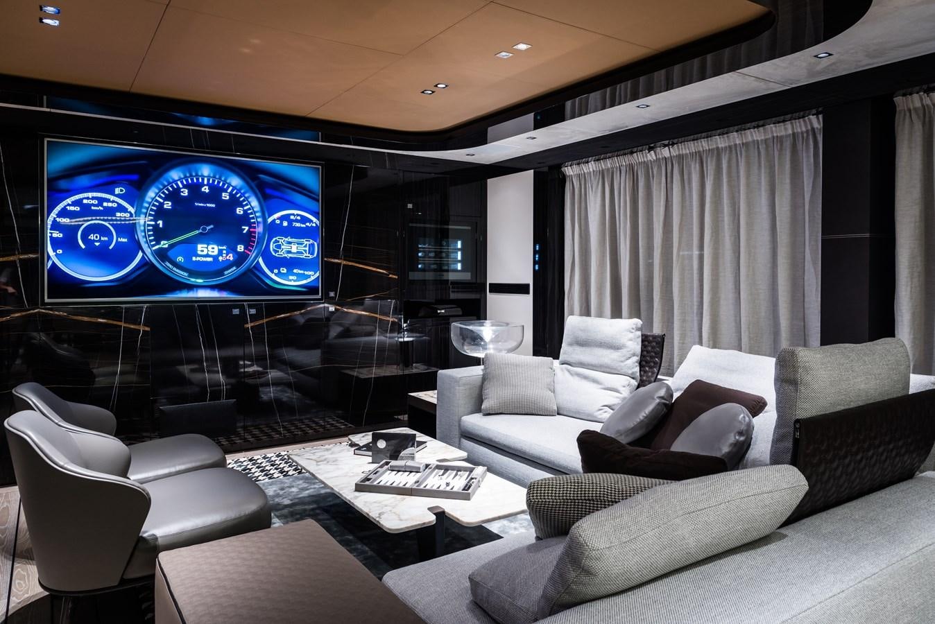 a room with a couch and a tv on the wall aboard DYNAMIQ GTT 115  Yacht for Sale