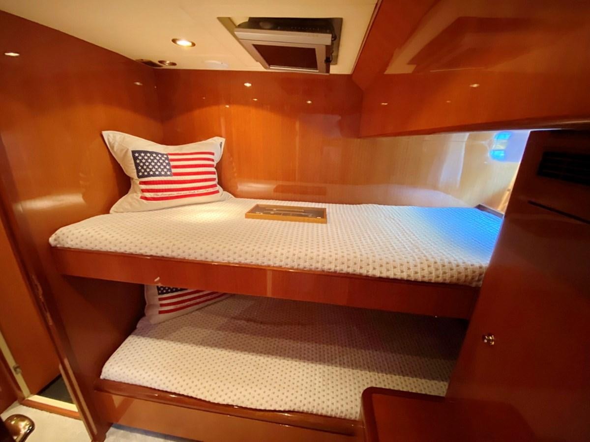 a bed with a white sheet and a red and white striped pillow aboard MARACAIBO Yacht for Sale