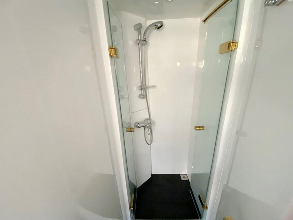 a bathroom with a shower and a black floor aboard MARACAIBO Yacht for Sale