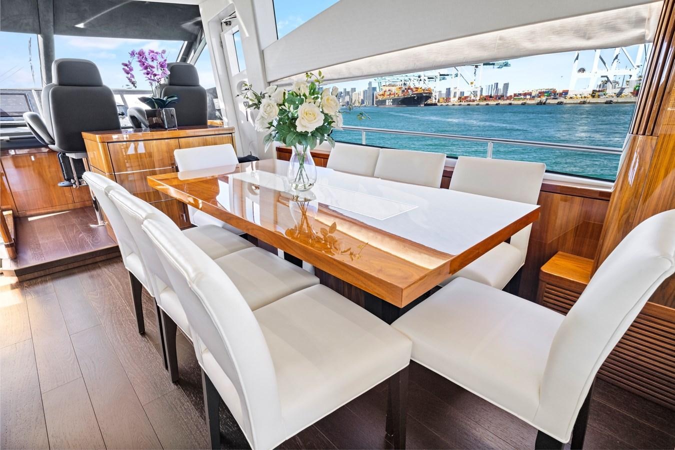 a room with a table chairs and a vase of flowers aboard MISTY K Yacht for Sale