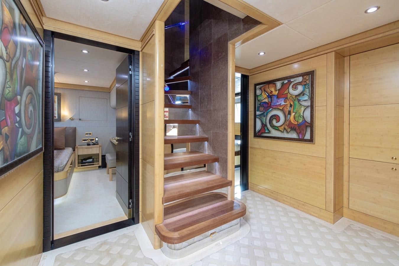a large room with a staircase and paintings on the wall aboard LADY TAHITI Yacht for Sale
