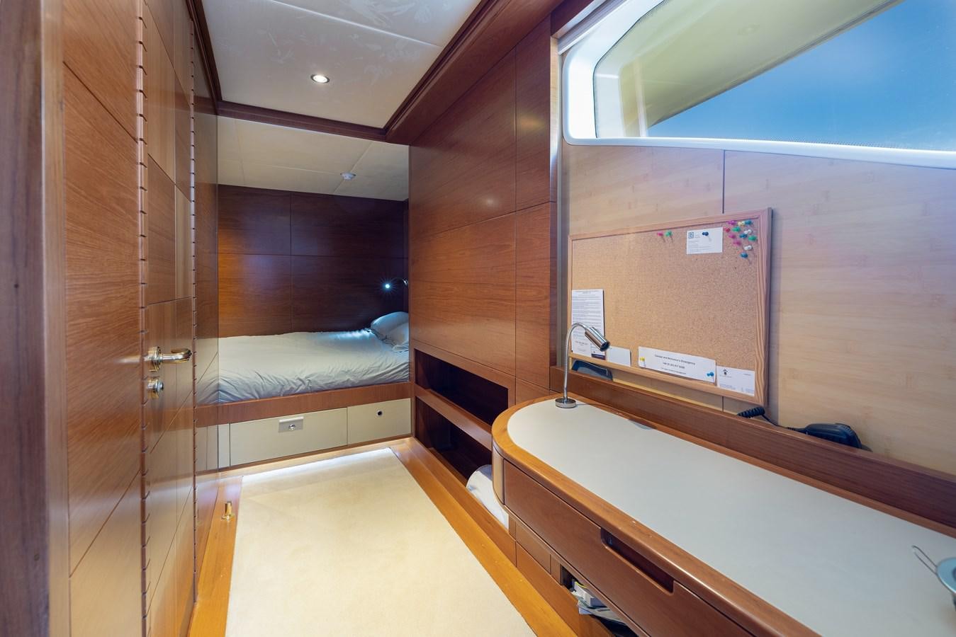 a room with a bed and a desk aboard LADY TAHITI Yacht for Sale