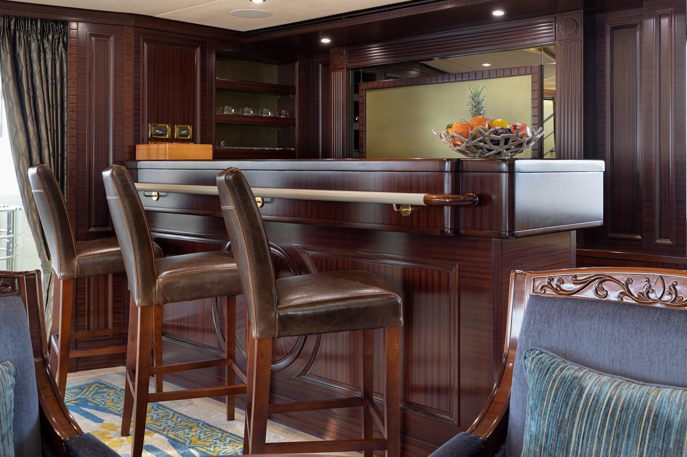 a kitchen with a bar and chairs aboard LADY TAHITI Yacht for Sale