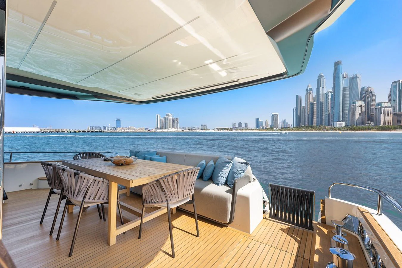 a table and chairs on a deck overlooking a city aboard MOSHE Yacht for Sale