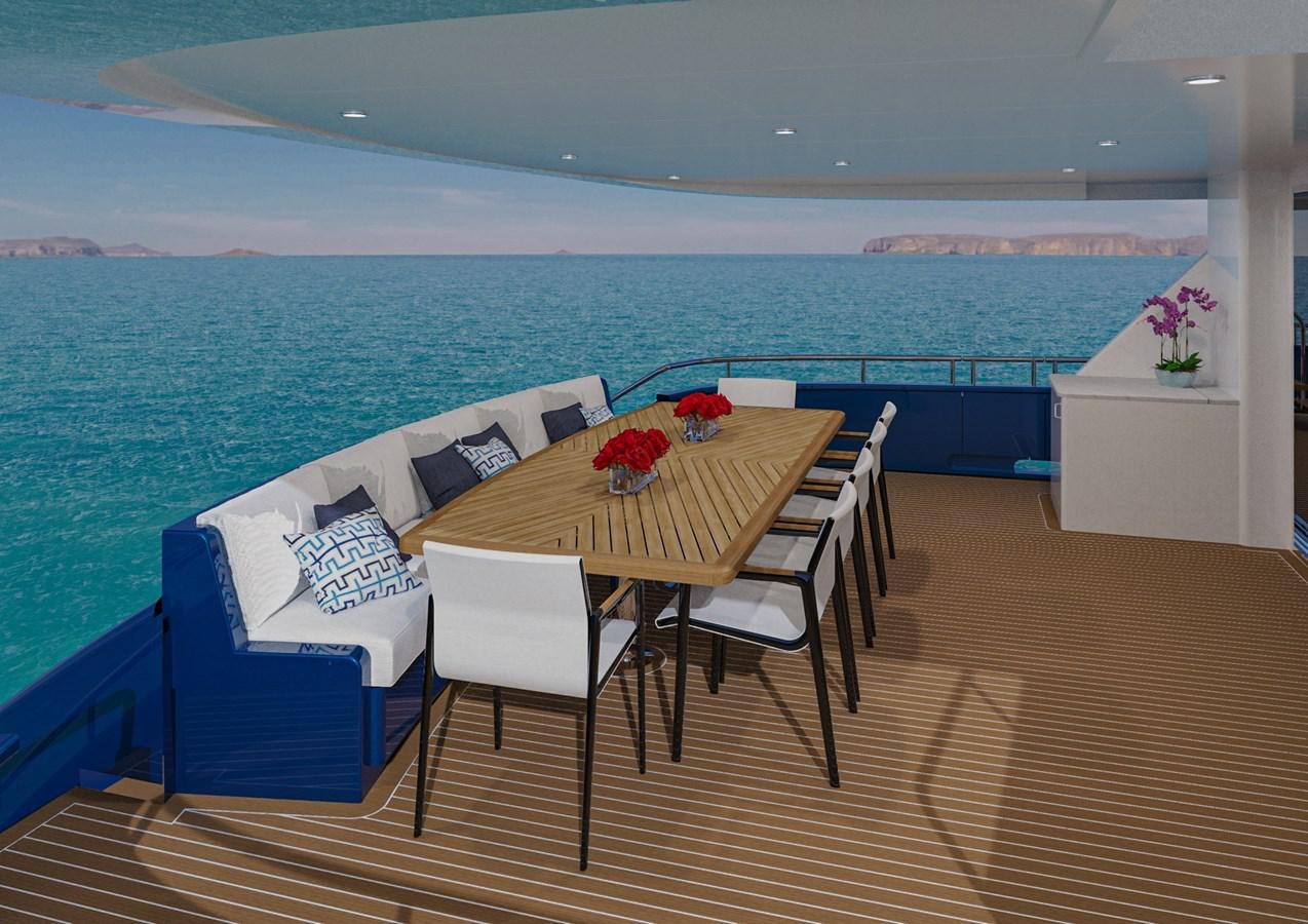 a table and chairs on a deck overlooking a beach aboard STELLARONE AL108 Yacht for Sale