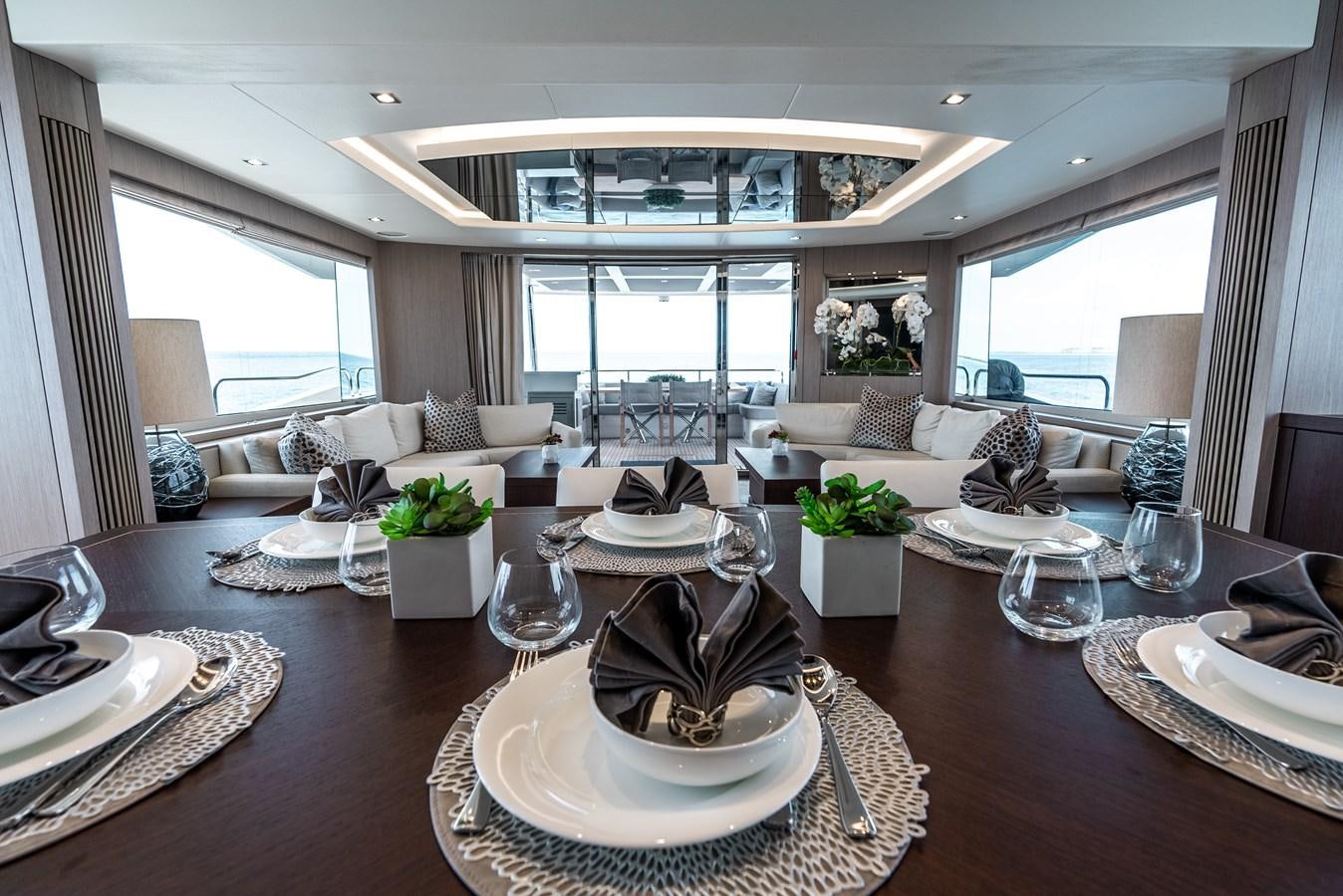 a large living room with a large dining table aboard F5 Yacht for Sale
