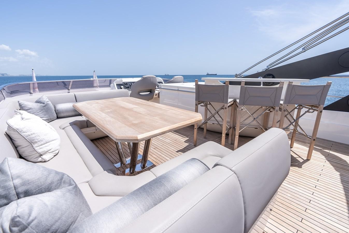 a deck with a table and chairs aboard F5 Yacht for Sale