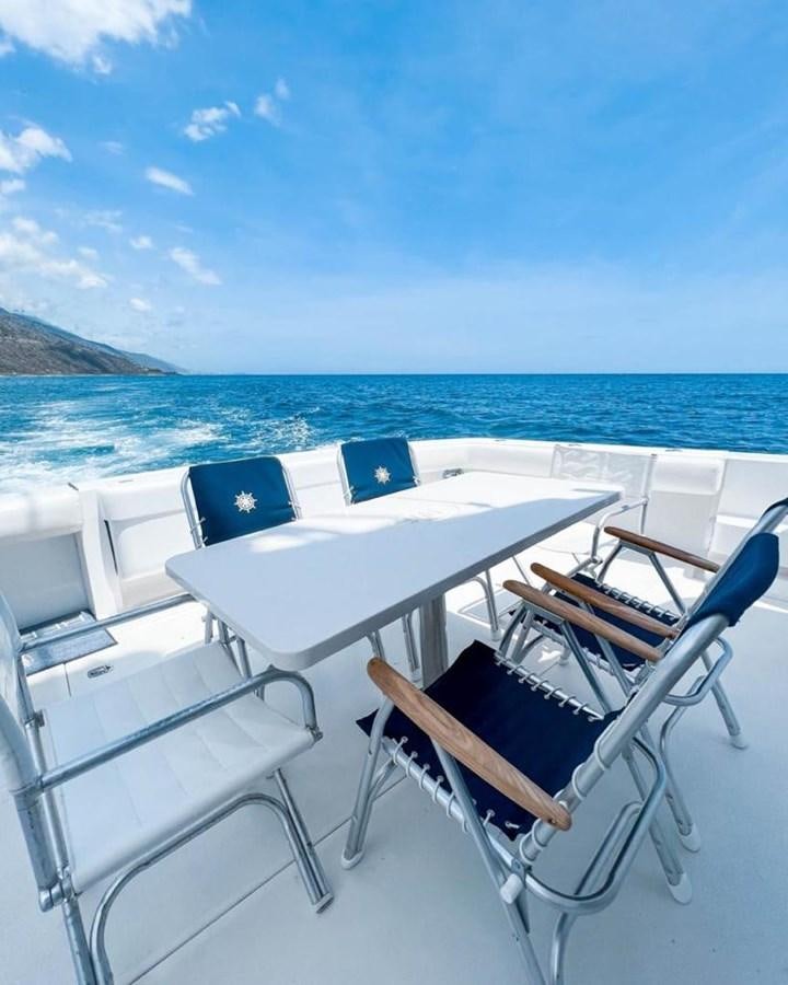 a table and chairs on a boat aboard BERTRAM 66 Yacht for Sale