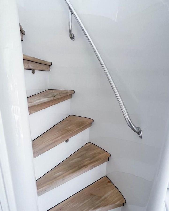 a wooden staircase with a metal railing aboard BERTRAM 66 Yacht for Sale
