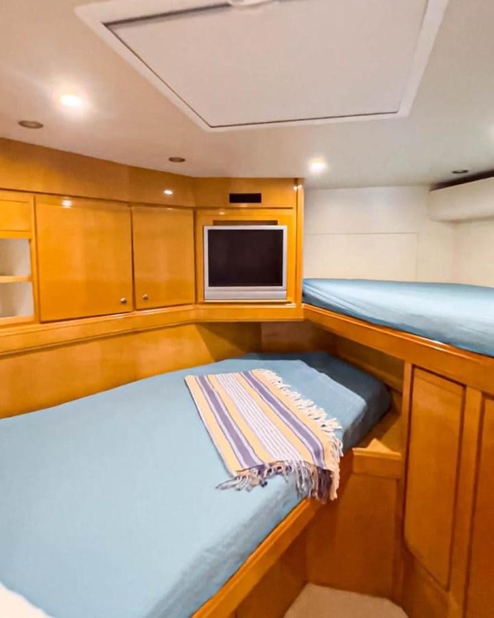 a room with a bed and a tv aboard BERTRAM 66 Yacht for Sale