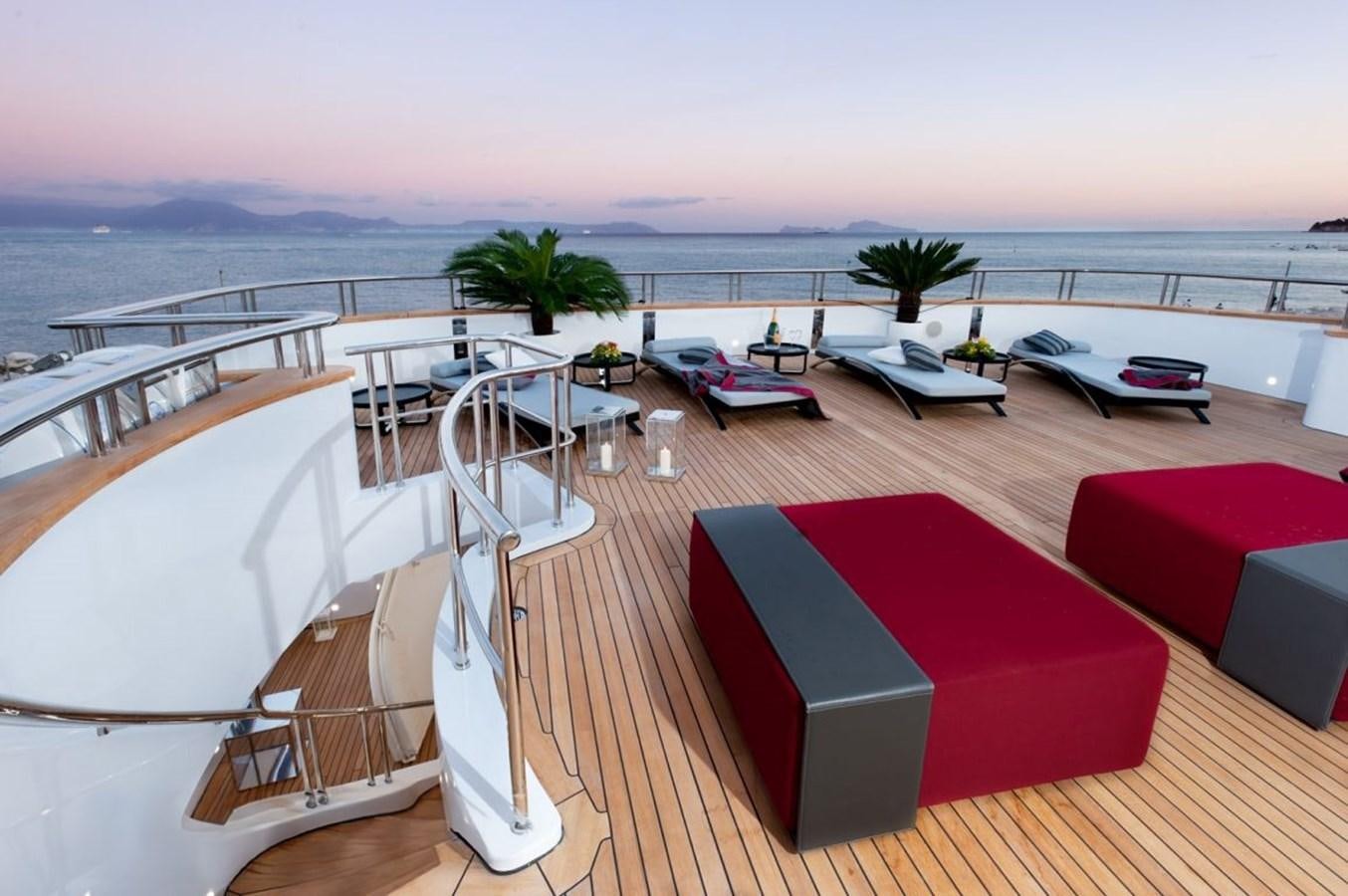 a deck with a pool and a deck with chairs and tables on it aboard ARMADA Yacht for Sale