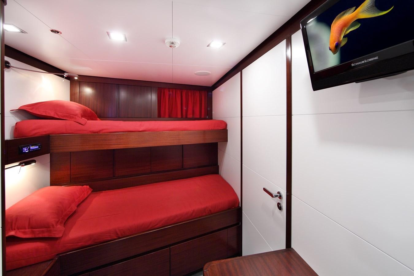 a room with a bed and a television on the wall aboard ARMADA Yacht for Sale
