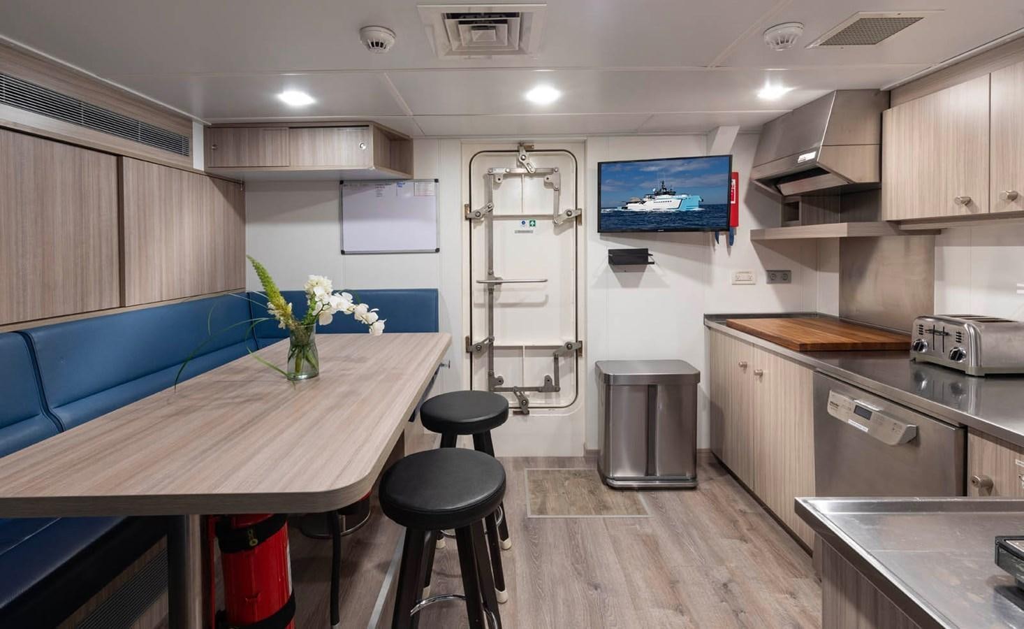a kitchen with a table and chairs aboard SHADOW Yacht for Sale