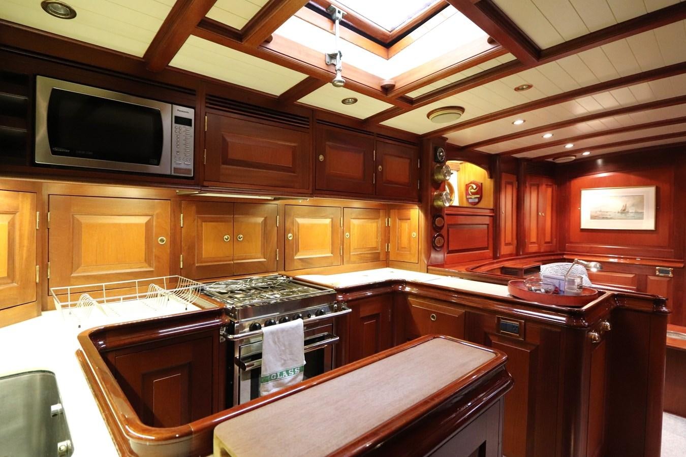 a kitchen with wooden cabinets aboard BRAVEHEART OF SARK Yacht for Sale