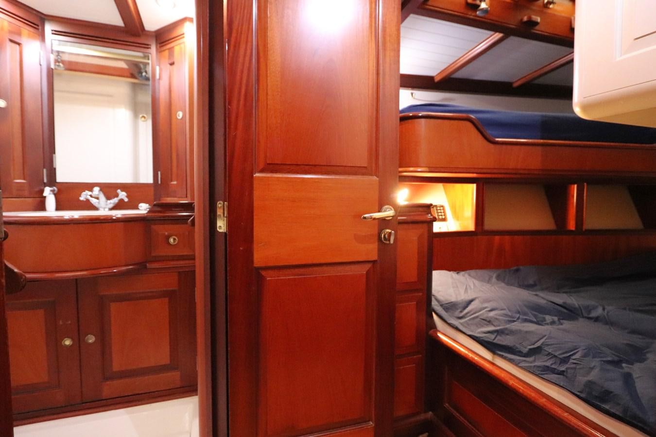 a bedroom with a bed and a sink aboard BRAVEHEART OF SARK Yacht for Sale