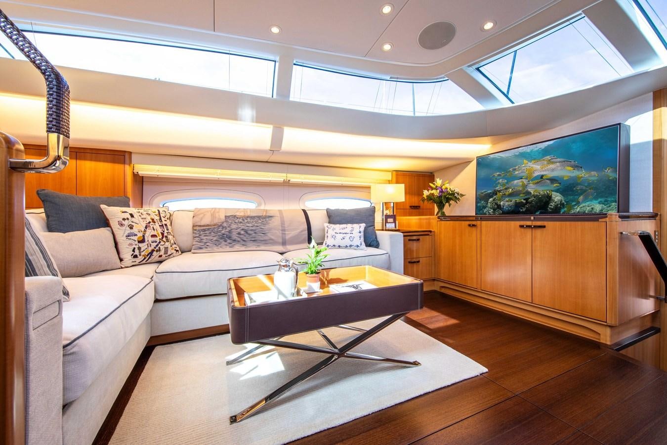 a living room with a large coffee table and a large window aboard MINI Y Yacht for Sale