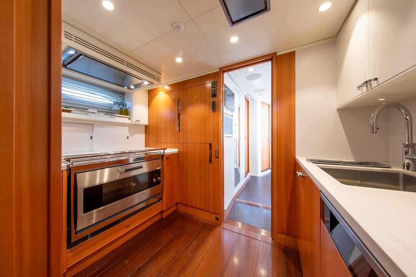 a kitchen with wooden cabinets aboard MINI Y Yacht for Sale