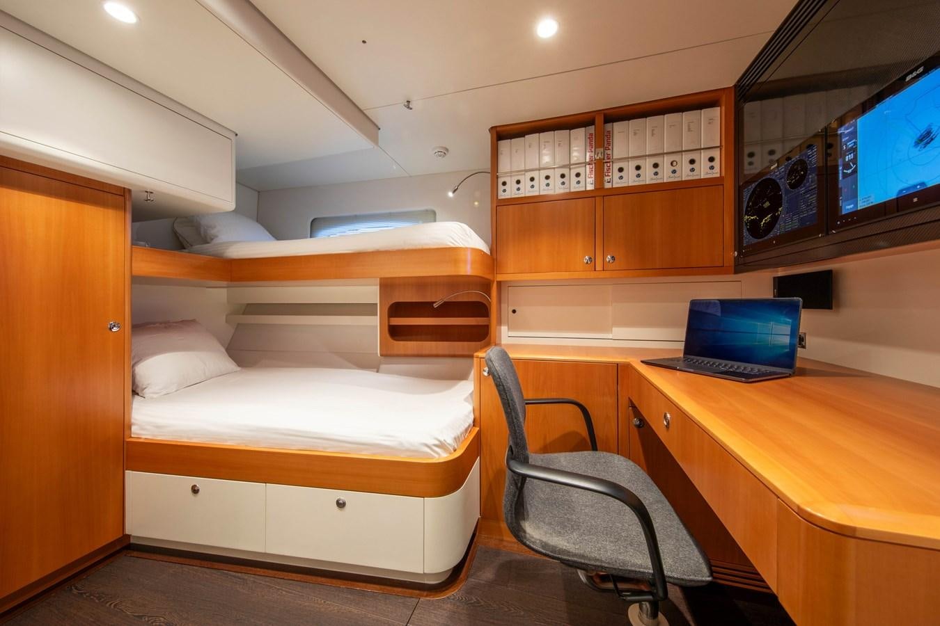 a room with bunk beds and a laptop on a desk aboard MINI Y Yacht for Sale