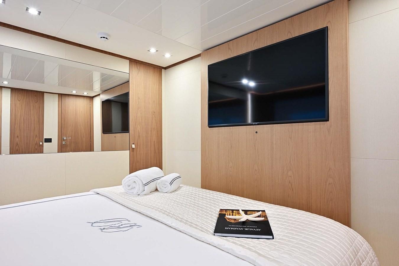a bed with a white sheet and a black television on the wall aboard HULL 21 Yacht for Sale