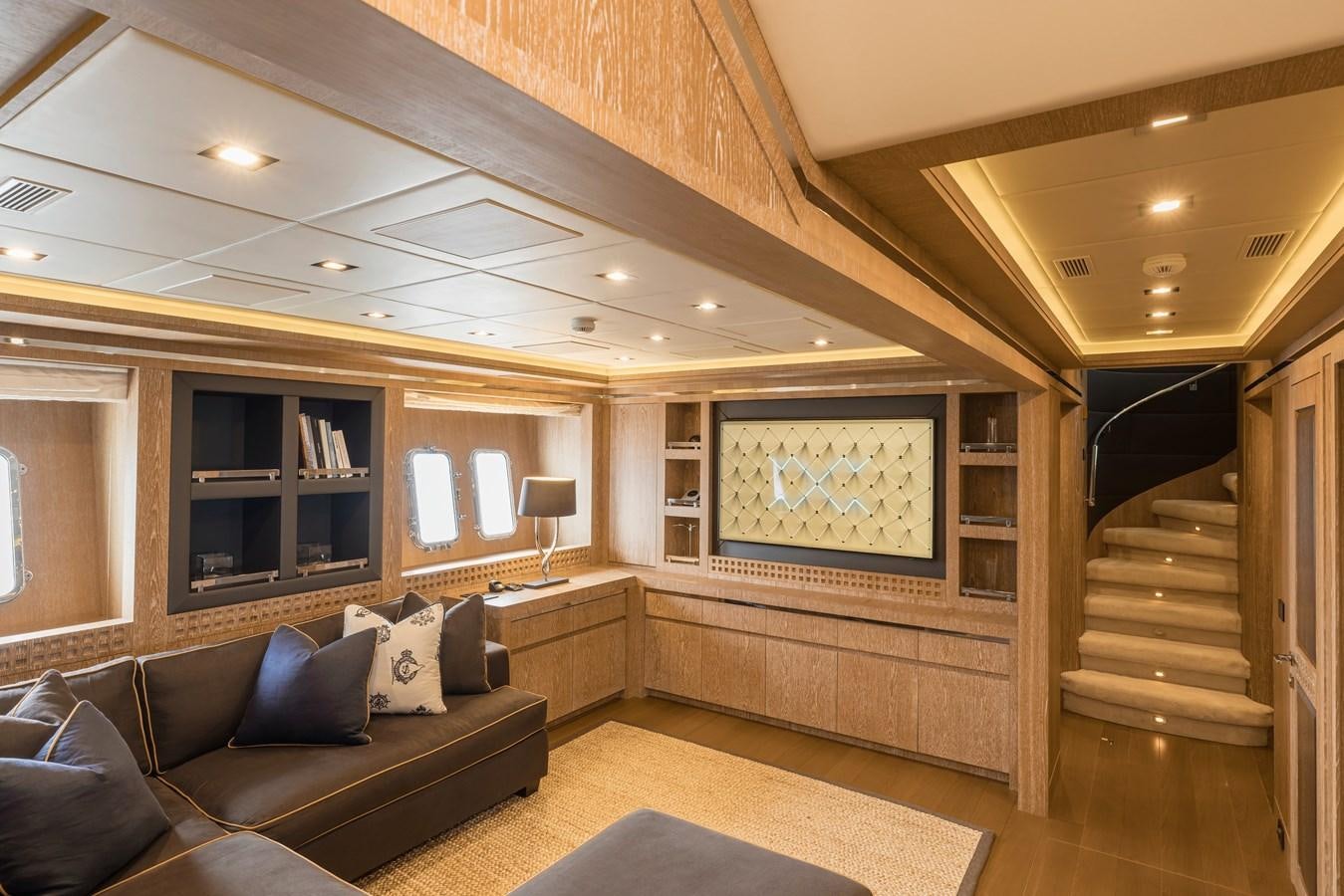 a living room with a large wood staircase and a large window aboard ROYALE X Yacht for Sale