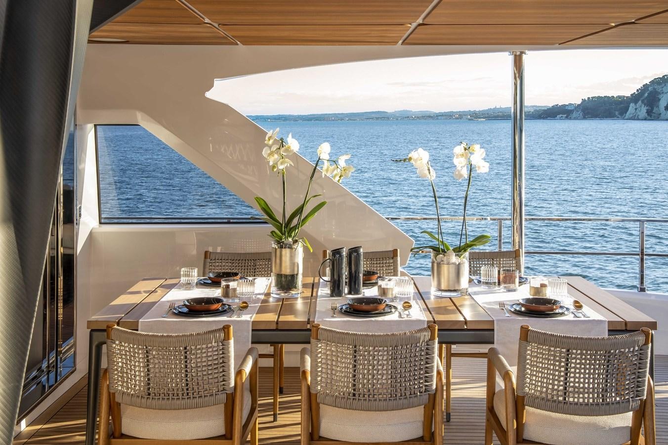 a table with chairs and flowers on it aboard CUSTOM LINE NAVETTA 33/33 Yacht for Sale