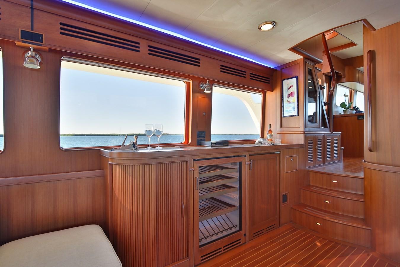a room with a large window and a wood cabinet aboard BESPOKE Yacht for Sale