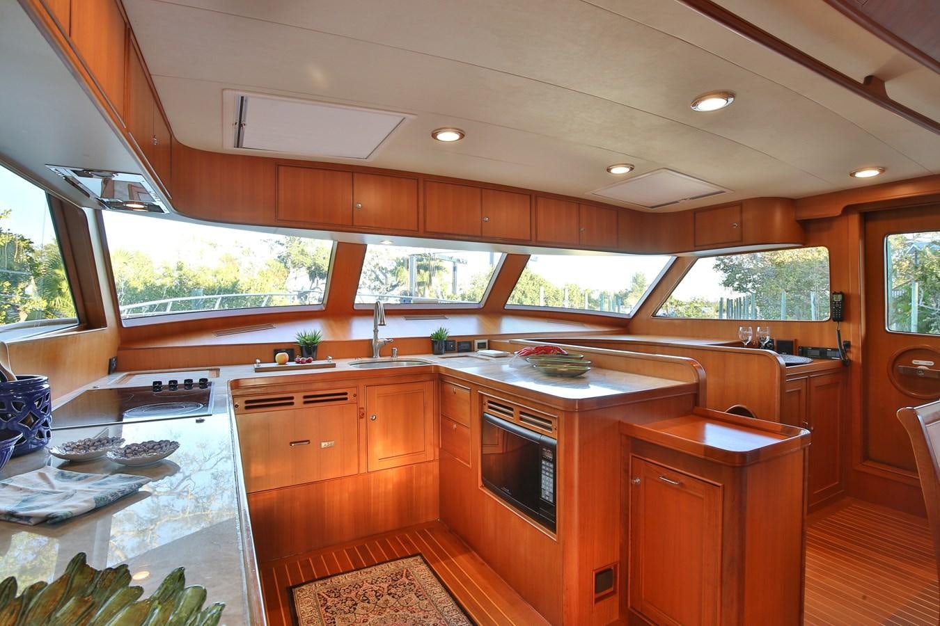 a kitchen with wooden cabinets aboard BESPOKE Yacht for Sale