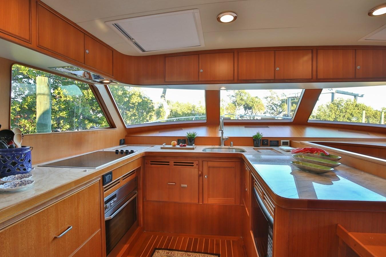 a kitchen with wooden cabinets aboard BESPOKE Yacht for Sale