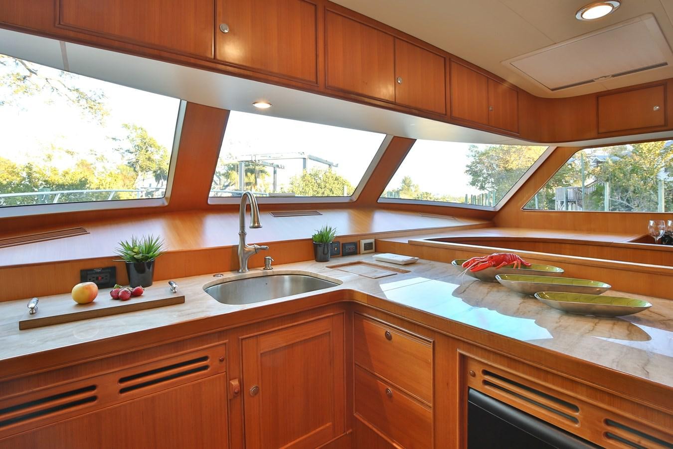 a kitchen with wooden cabinets aboard BESPOKE Yacht for Sale