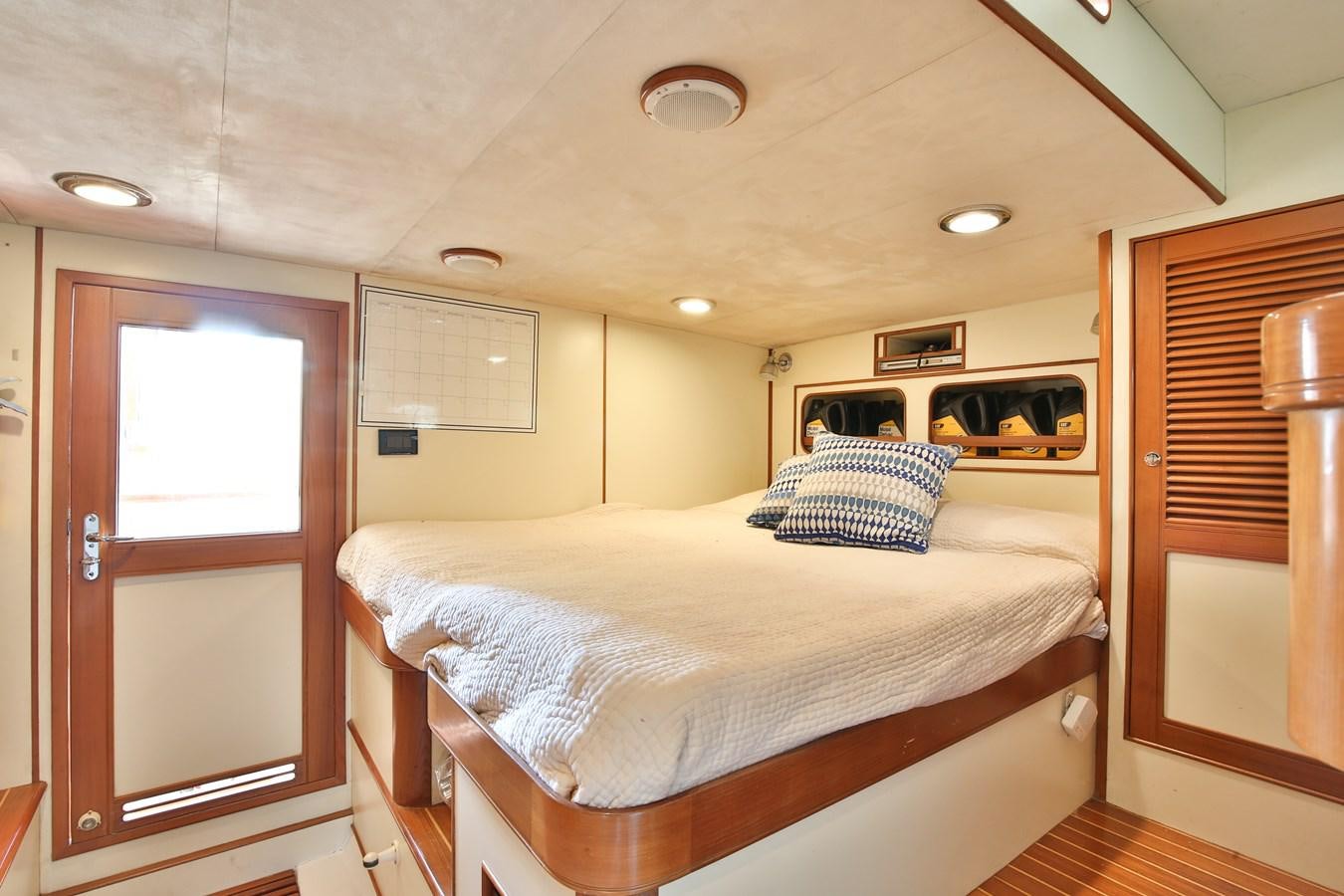 a bedroom with a bed and a closet aboard BESPOKE Yacht for Sale