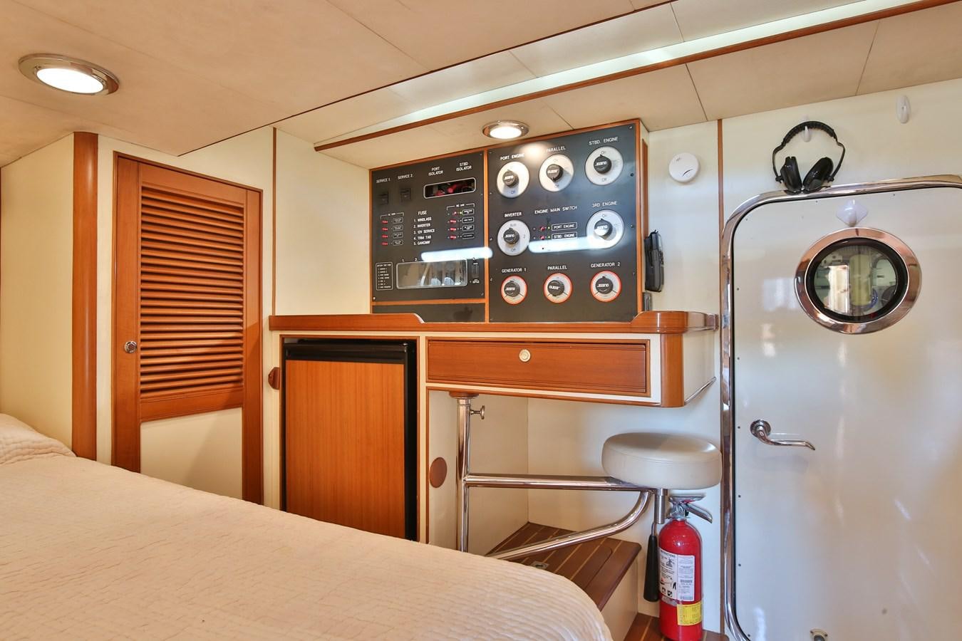 a room with a bed and a desk with a machine on it aboard BESPOKE Yacht for Sale