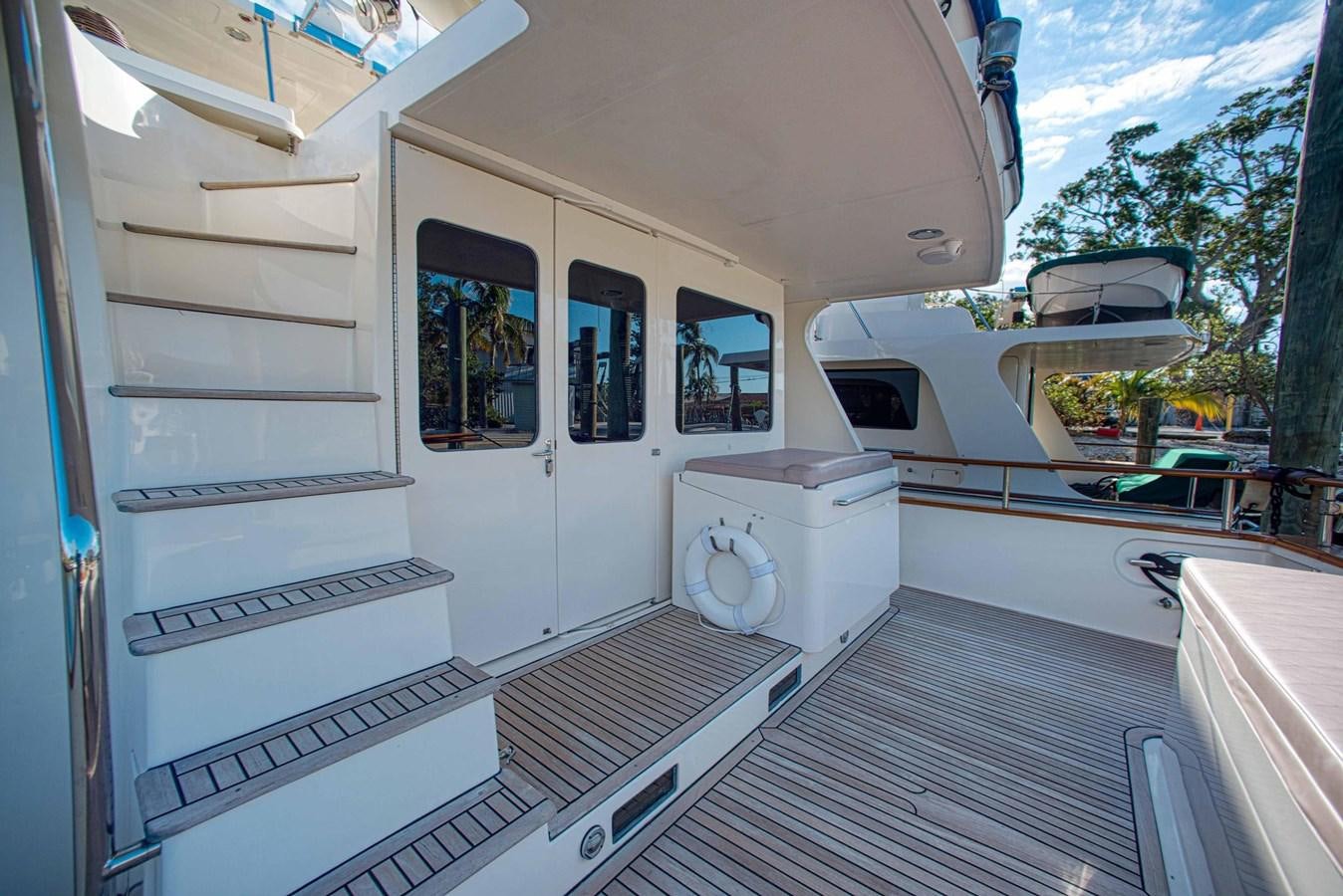 a small white house with a large deck and a large white barbecue grill aboard DISCONNECTED Yacht for Sale