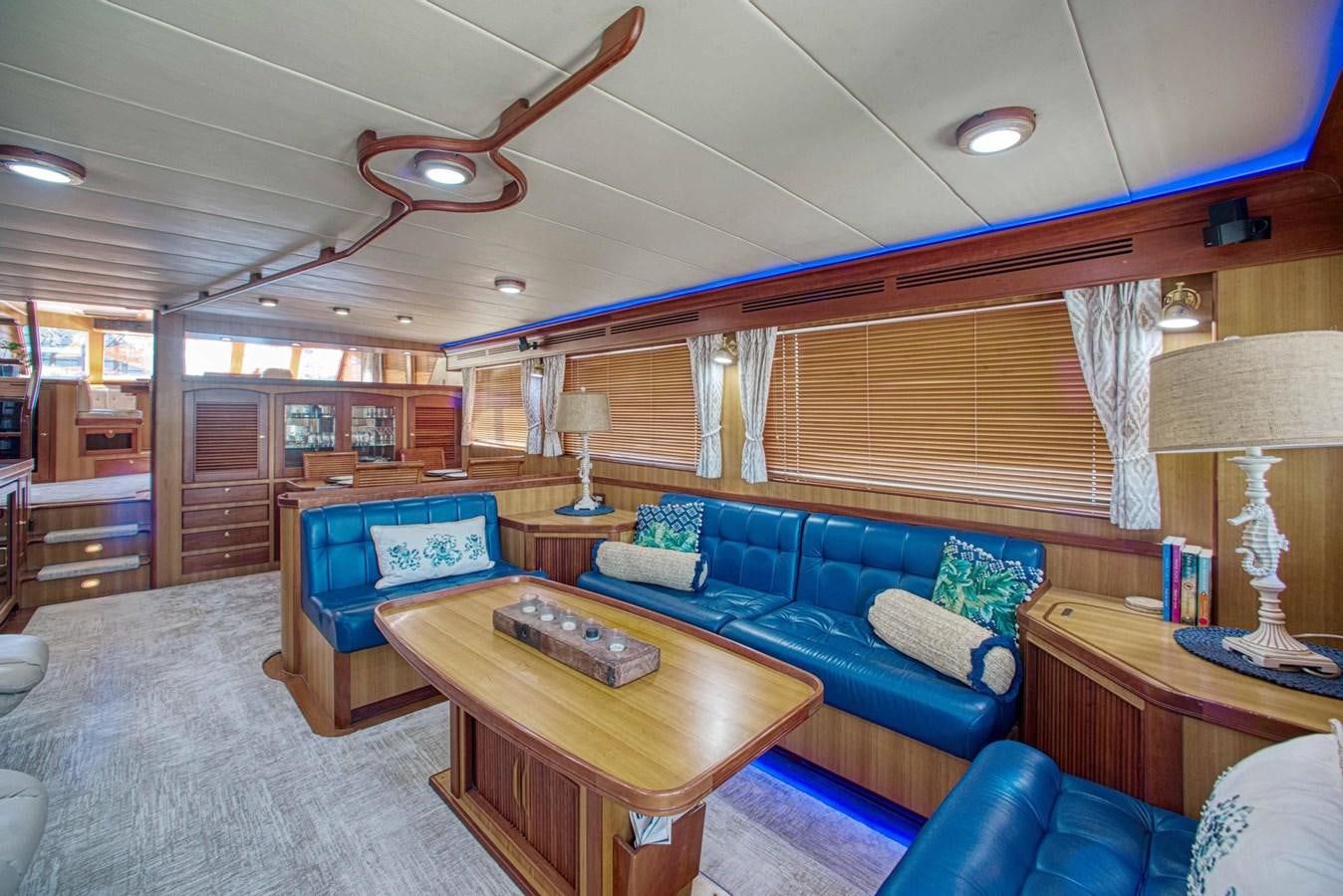 a living room with a blue couch and a wood coffee table aboard DISCONNECTED Yacht for Sale