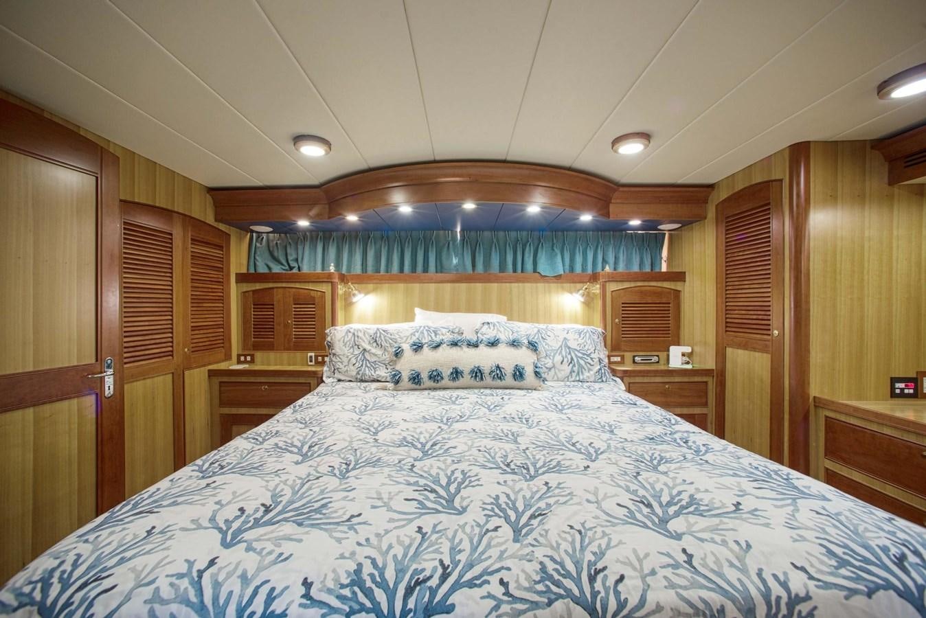 a bed with blue sheets aboard DISCONNECTED Yacht for Sale