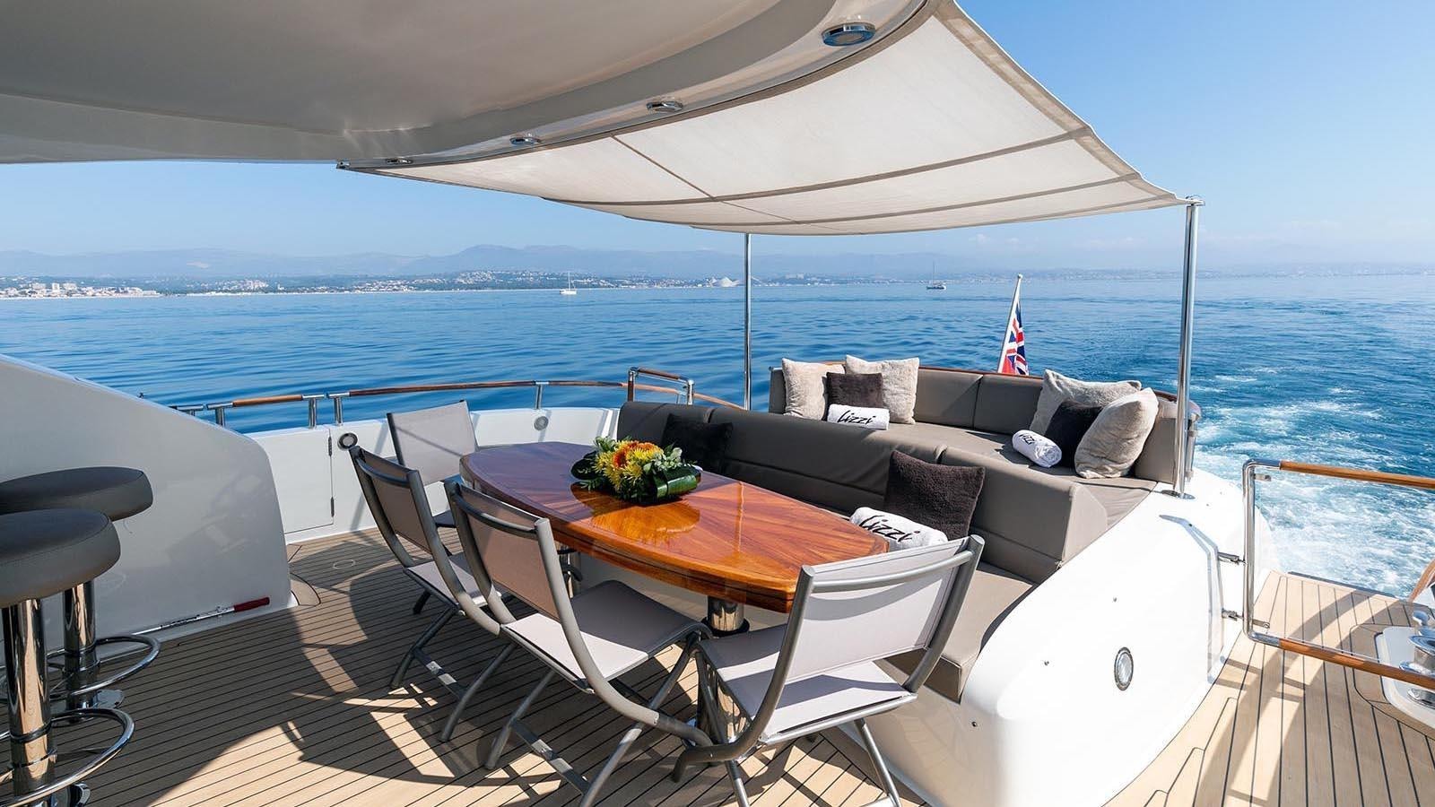 a table and chairs on a deck overlooking the ocean aboard 2008 LAZZARA LSX 75 Yacht for Sale