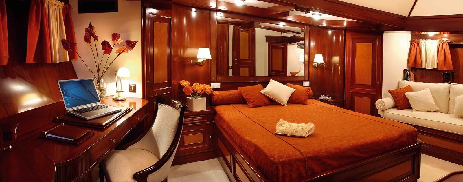 a bedroom with a bed and a desk aboard LIANA H Yacht for Sale