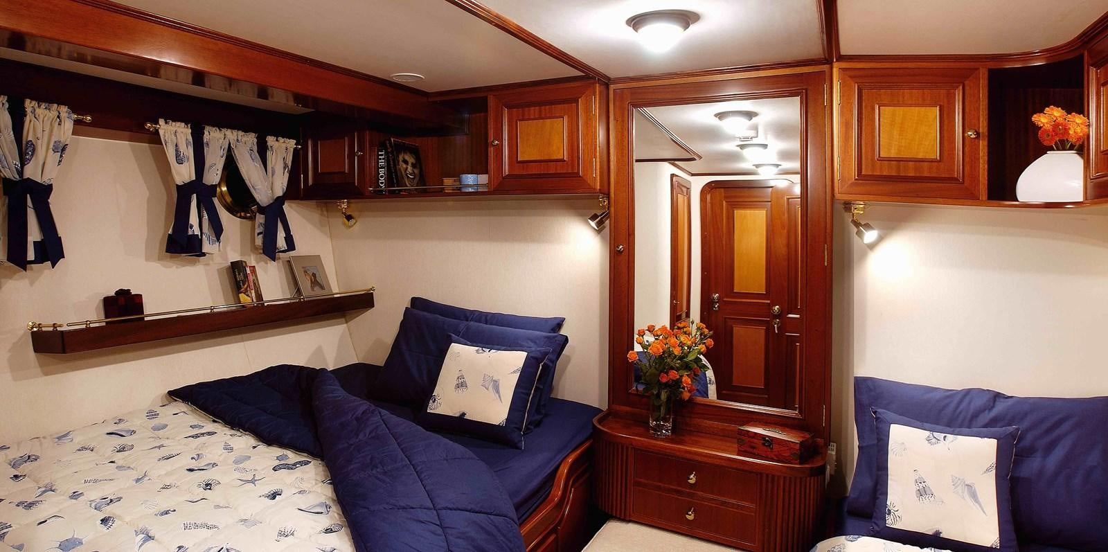 a bedroom with a bed and a dresser aboard LIANA H Yacht for Sale