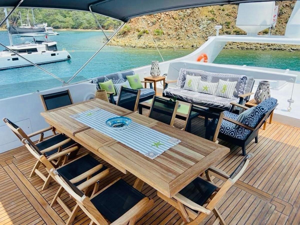a table and chairs on a deck aboard THIRTY LOVE Yacht for Sale