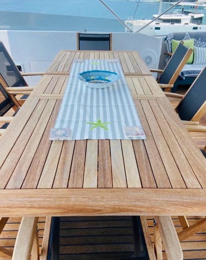 a deck with a table and chairs aboard THIRTY LOVE Yacht for Sale