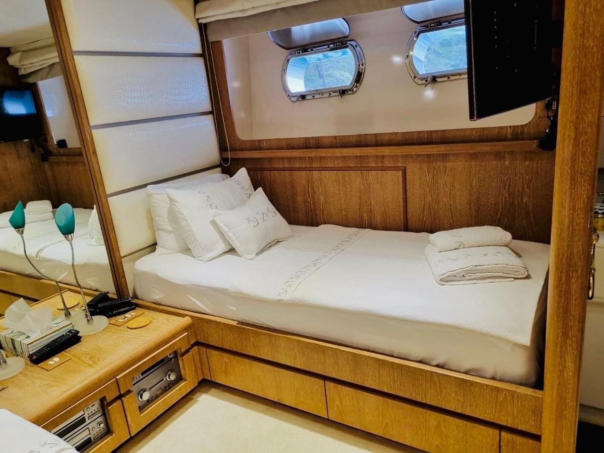 a bed with a white sheet and a mirror above it aboard THIRTY LOVE Yacht for Sale