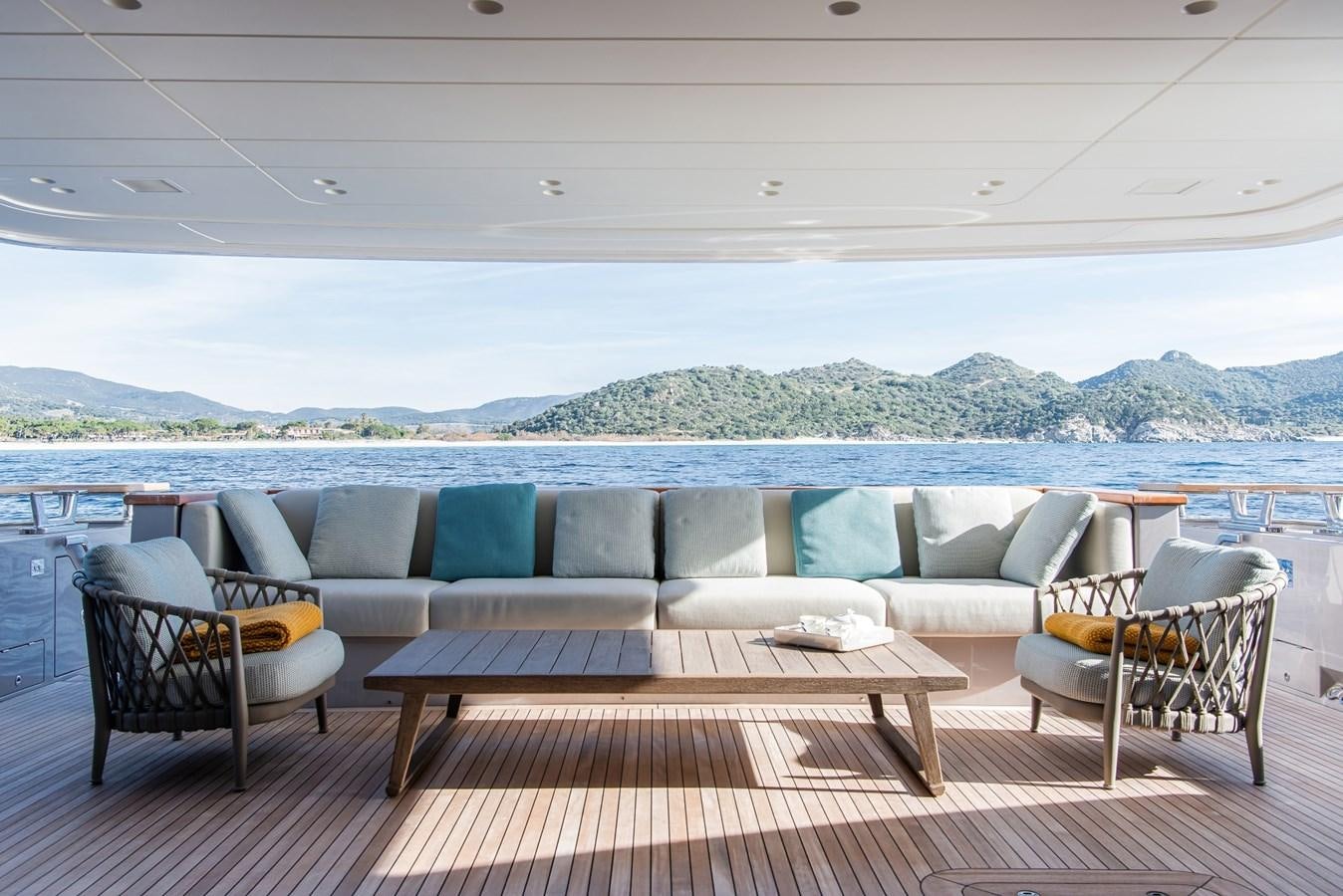 a deck with chairs and a body of water in the background aboard STONE HILLS Yacht for Sale