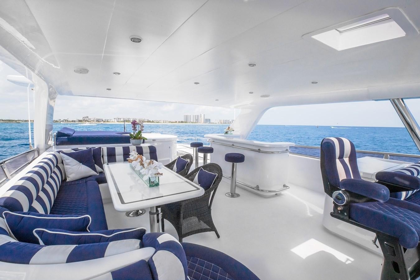 a room with a table chairs and a large pool aboard BAD DADDY Yacht for Sale