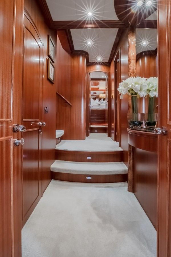 a room with a wood door and a vase with flowers on the floor aboard BAD DADDY Yacht for Sale