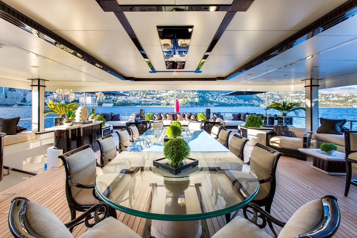 a room with a table chairs and plants in it aboard LIONESS V Yacht for Sale