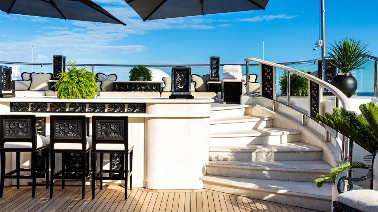 a deck with a pool and a deck with chairs and plants aboard LIONESS V Yacht for Sale