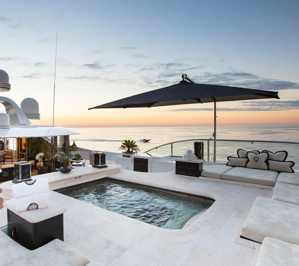 a large pool with a large building in the background aboard LIONESS V Yacht for Sale