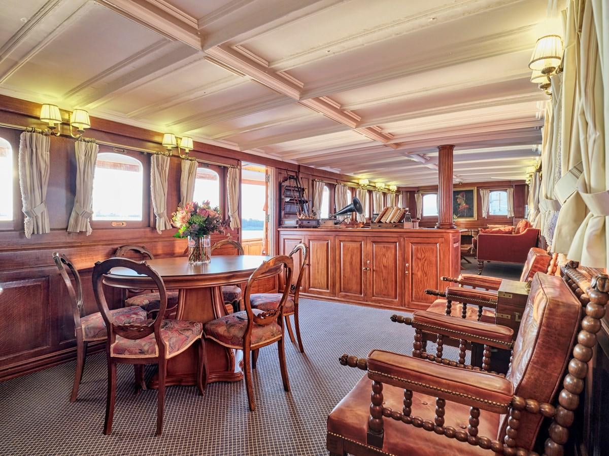 a large dining room with wood furniture aboard MADIZ Yacht for Sale