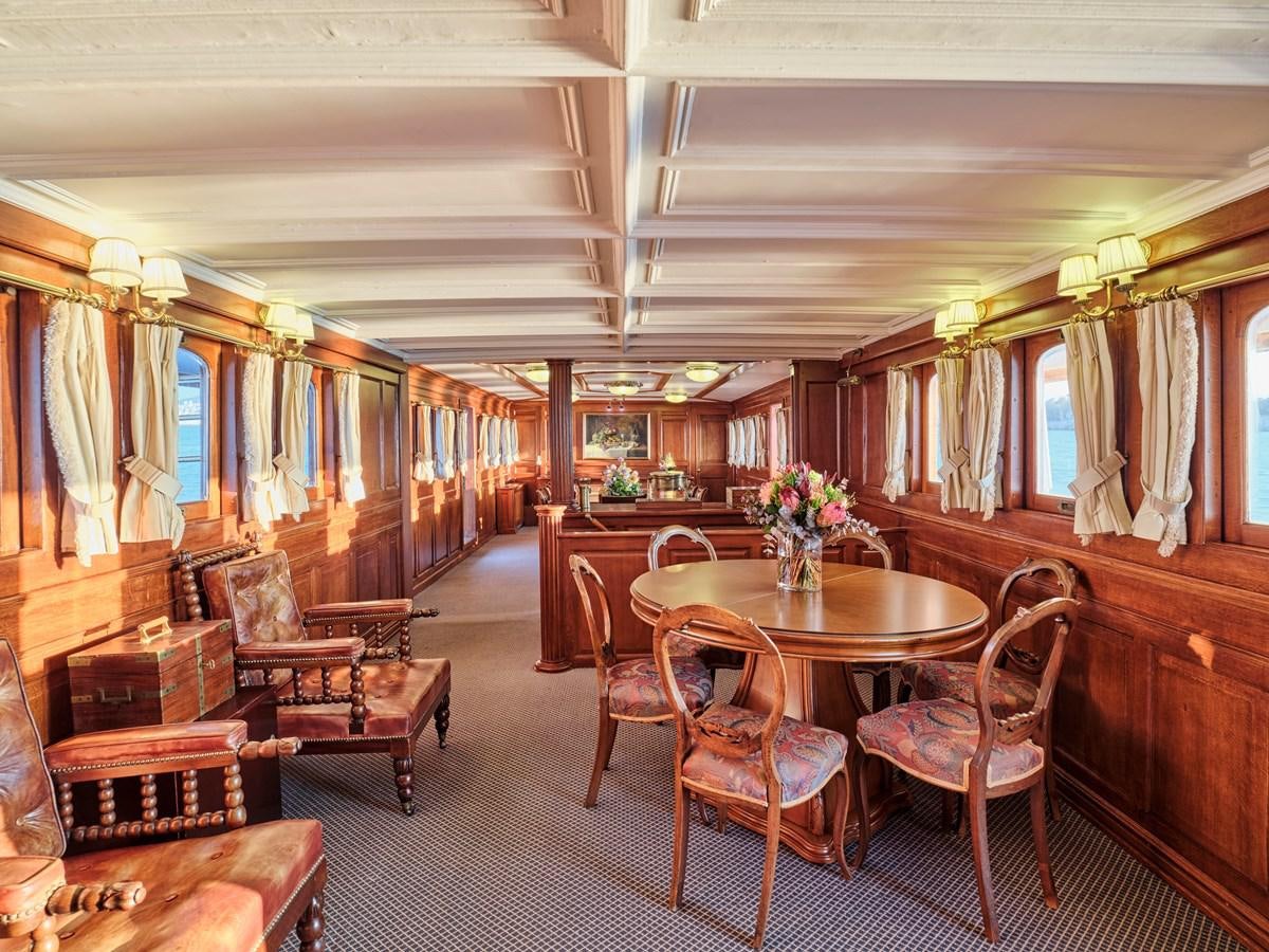 a room with a table chairs and a bench aboard MADIZ Yacht for Sale