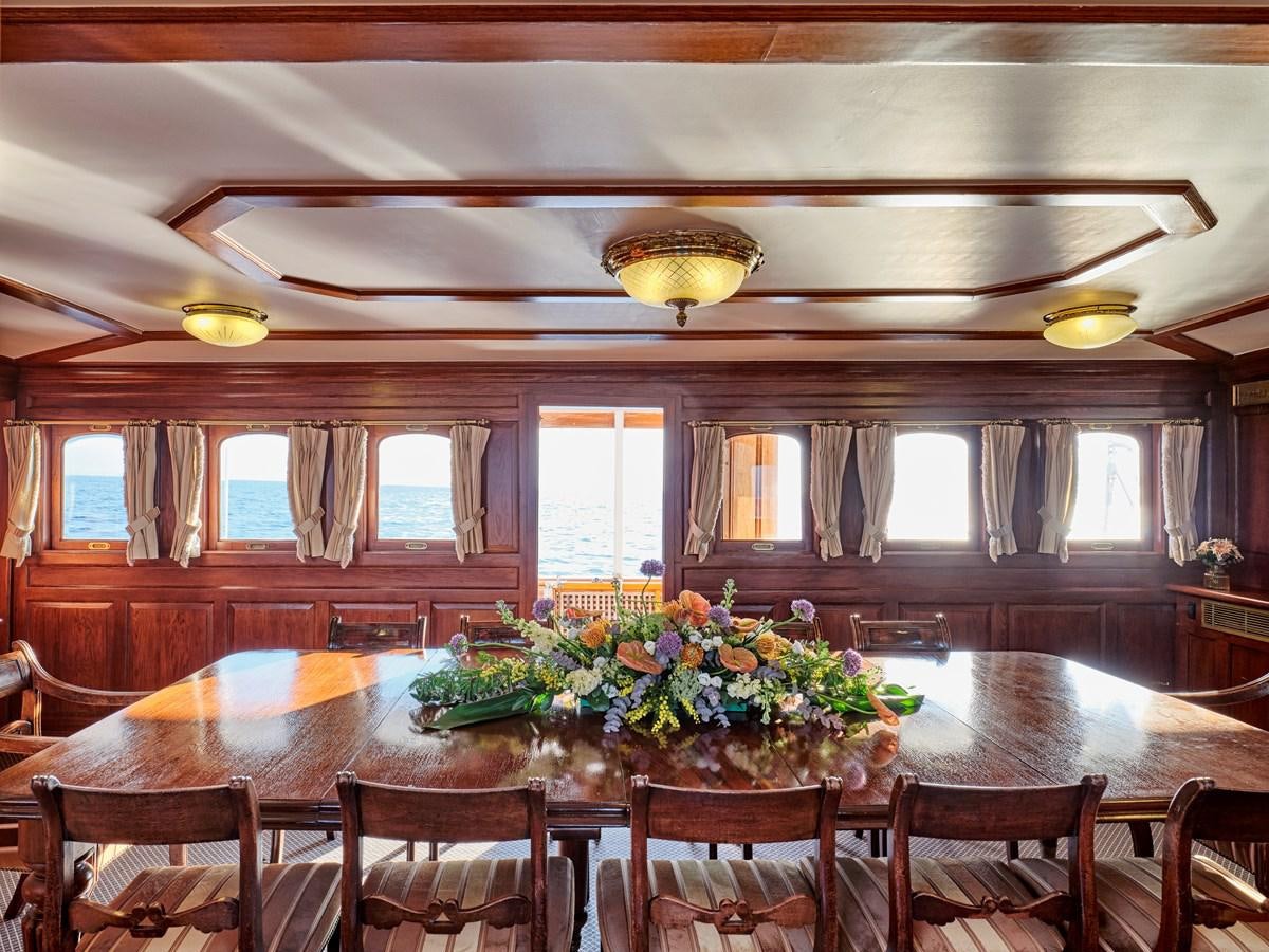 a room with tables and chairs aboard MADIZ Yacht for Sale